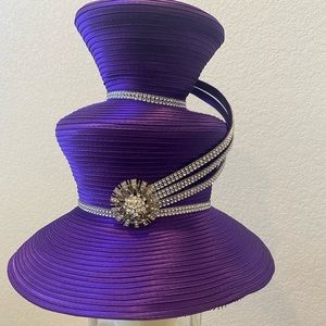 A purple Whittall & Son designer hat, with an beautiful diamond like pendant.